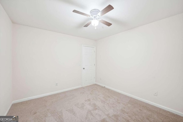 spare room with ceiling fan and light carpet