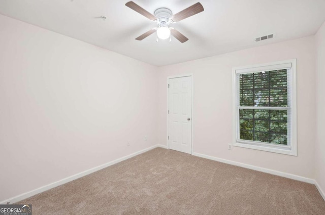 carpeted spare room featuring ceiling fan