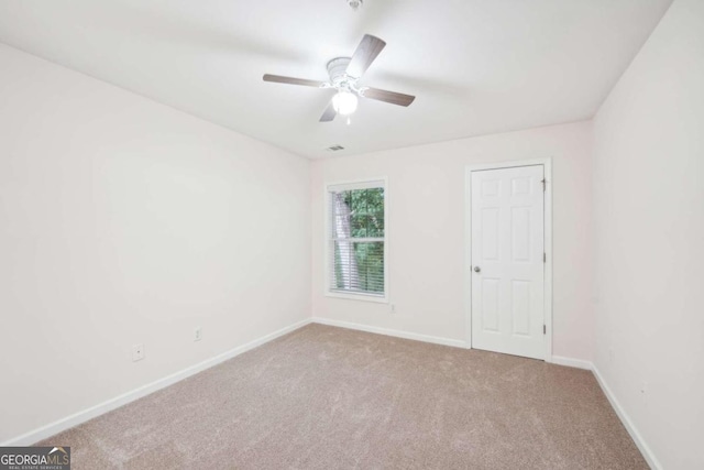 unfurnished room with ceiling fan and light carpet