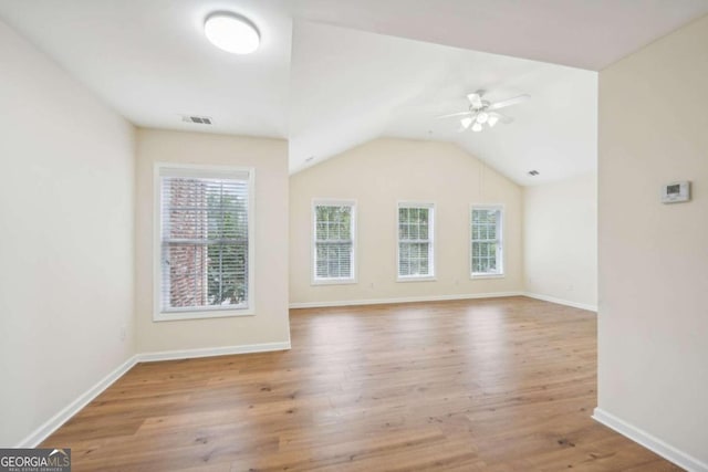 spare room featuring lofted ceiling, ceiling fan, and light hardwood / wood-style flooring