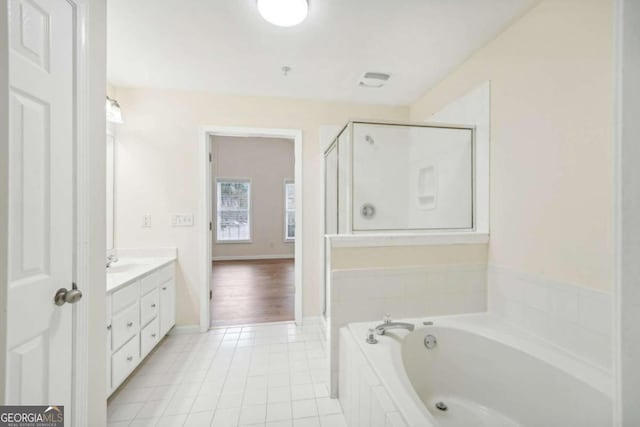 bathroom featuring tile patterned flooring, vanity, and plus walk in shower