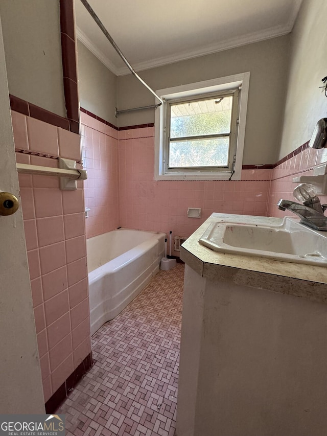 bathroom with tile walls, vanity, ornamental molding, and shower / washtub combination