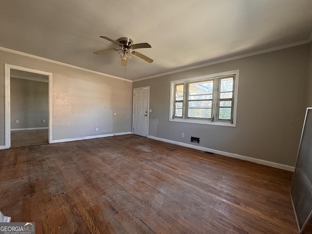 spare room featuring dark wood-type flooring, ceiling fan, and crown molding