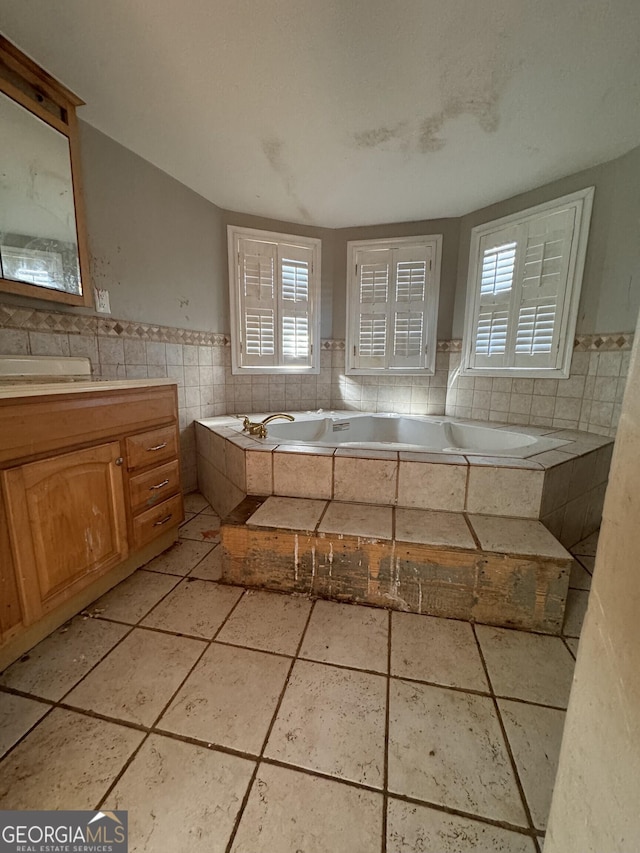 bathroom with plenty of natural light, tile walls, and tiled bath