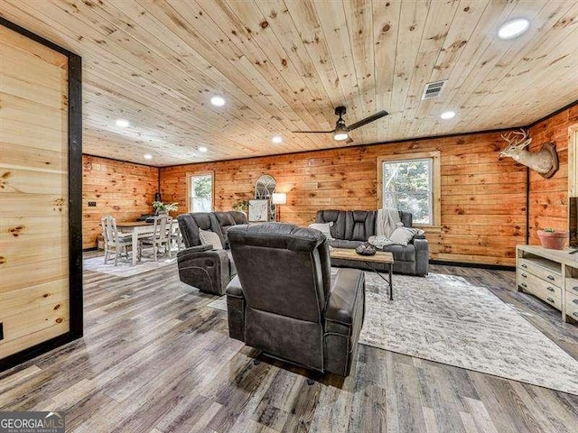 living room featuring dark wood-type flooring, wooden walls, and wooden ceiling