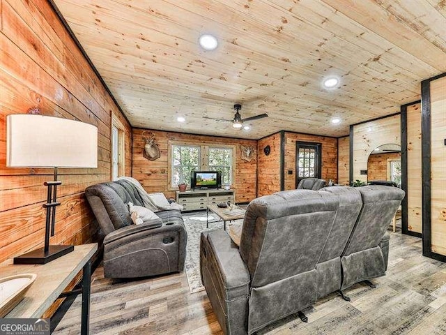 living room featuring hardwood / wood-style flooring, wooden ceiling, wooden walls, and a wealth of natural light