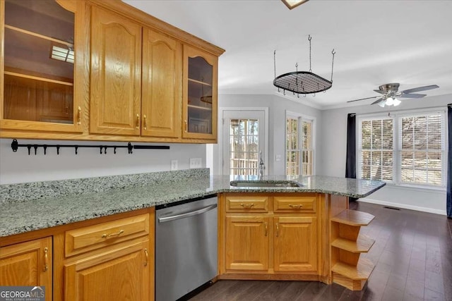 kitchen with sink, light stone counters, stainless steel dishwasher, ornamental molding, and dark hardwood / wood-style flooring