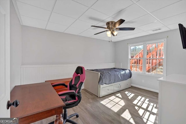 bedroom featuring hardwood / wood-style flooring, a paneled ceiling, and ceiling fan