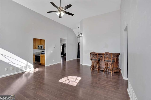 living room featuring high vaulted ceiling, ceiling fan with notable chandelier, and dark hardwood / wood-style flooring