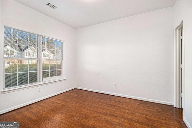 empty room with dark hardwood / wood-style flooring