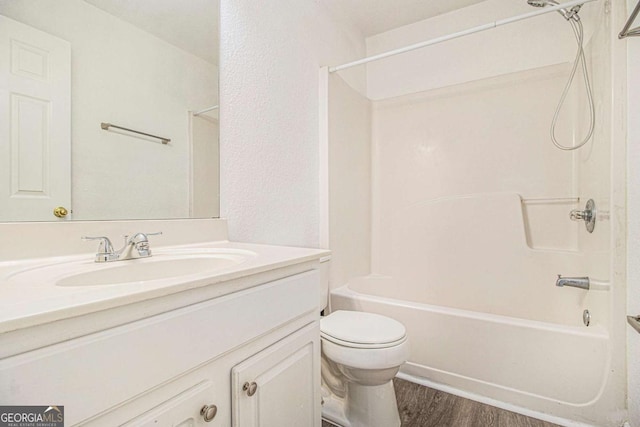 full bathroom with shower / bathing tub combination, vanity, wood-type flooring, and toilet