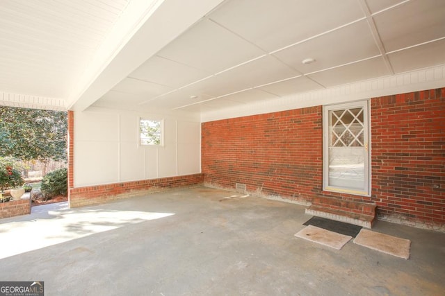 exterior space with concrete flooring and brick wall