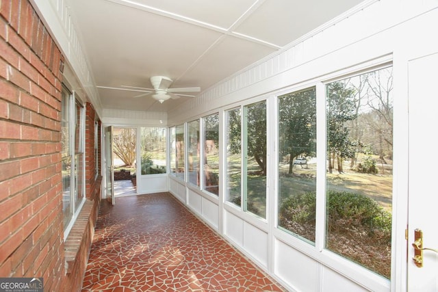 unfurnished sunroom featuring ceiling fan