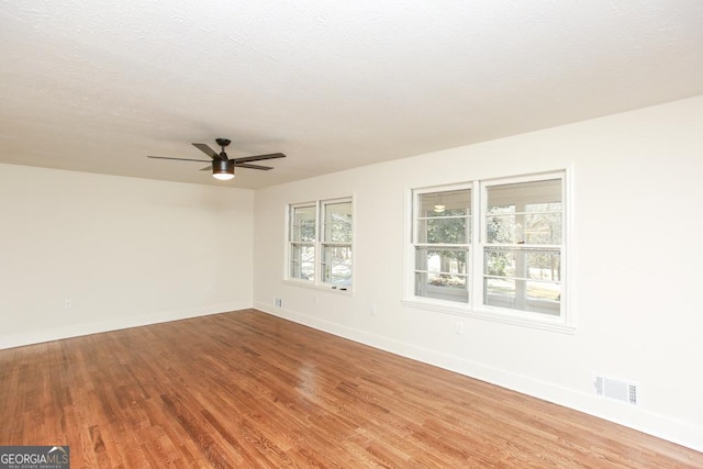 empty room featuring hardwood / wood-style flooring, ceiling fan, and a textured ceiling