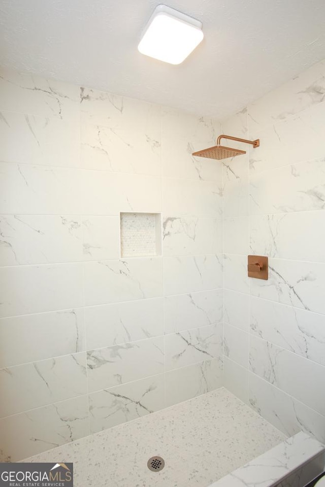 bathroom featuring a tile shower