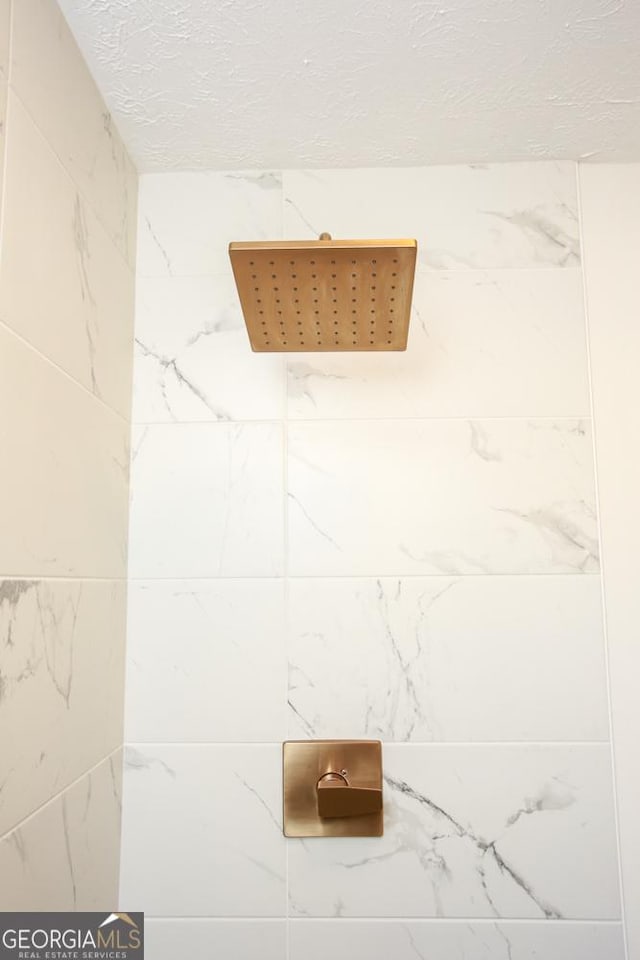 room details featuring a textured ceiling and walk in shower