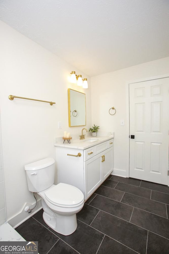 bathroom featuring tile patterned flooring, vanity, and toilet