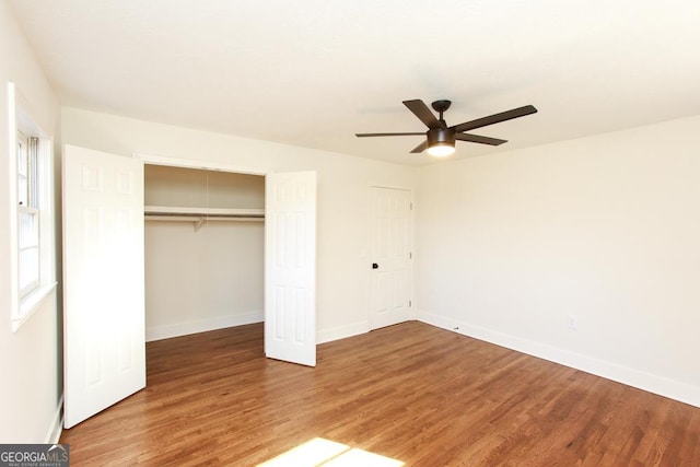 unfurnished bedroom featuring hardwood / wood-style floors, a closet, and ceiling fan