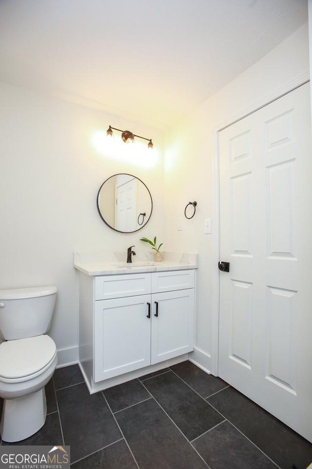 bathroom with tile patterned flooring, vanity, and toilet