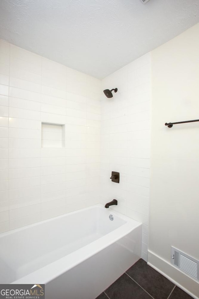 bathroom with tiled shower / bath and tile patterned floors