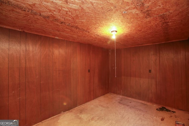 basement featuring wooden walls