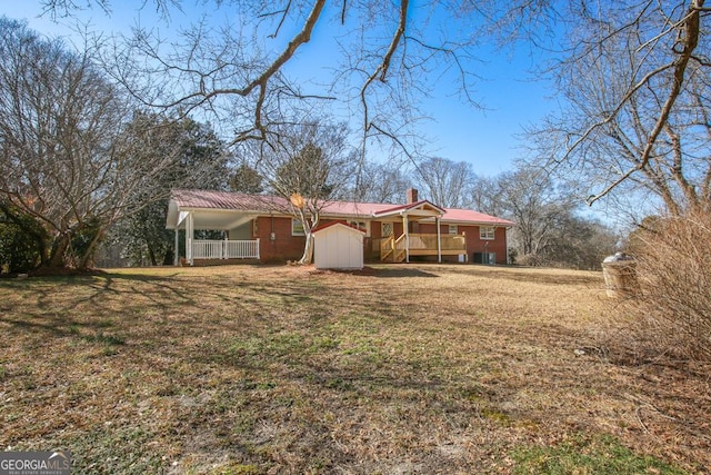 rear view of house with a porch, central air condition unit, and a lawn