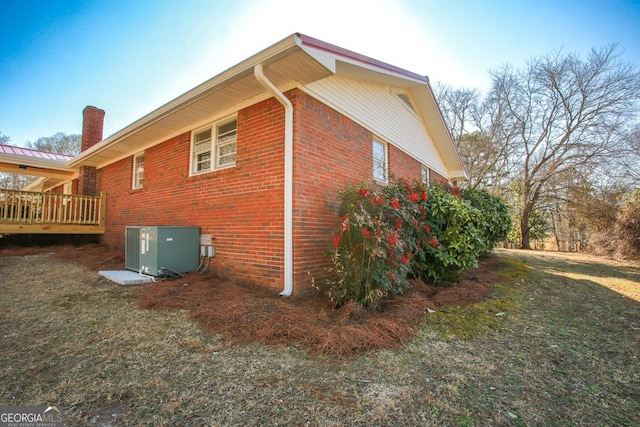 view of home's exterior featuring central AC, a deck, and a lawn