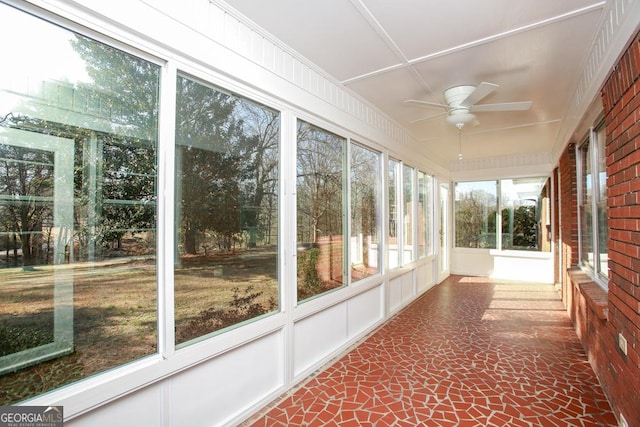 unfurnished sunroom with ceiling fan