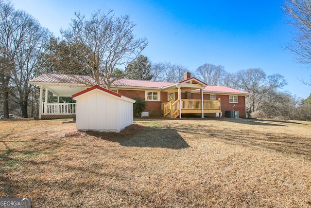 back of property featuring a porch, a wooden deck, a yard, and central AC unit