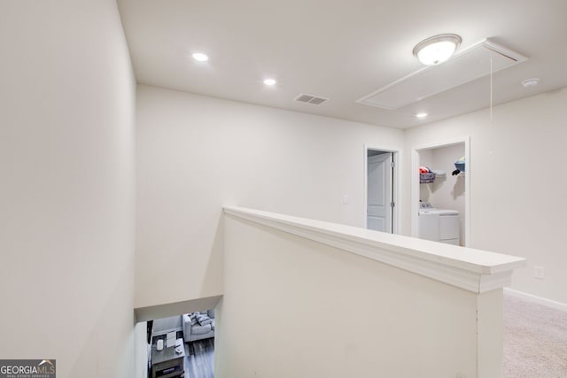 hallway featuring separate washer and dryer and carpet flooring