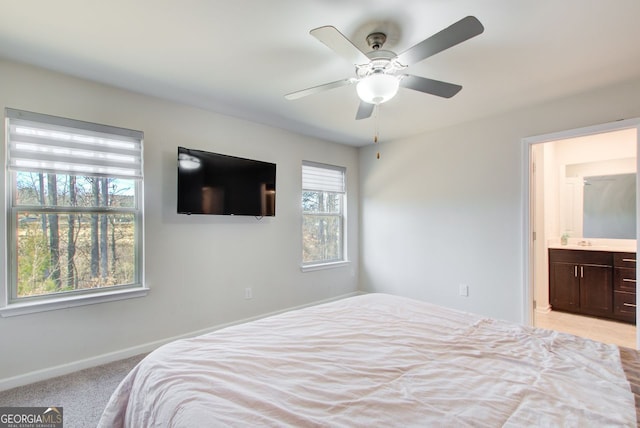 carpeted bedroom featuring ceiling fan and ensuite bath