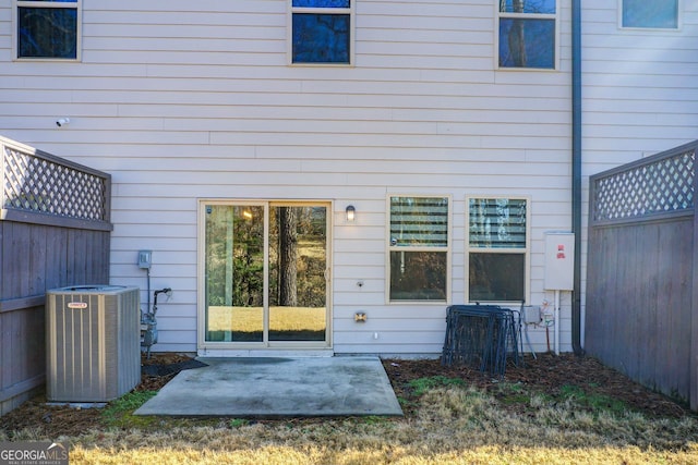 back of property with central AC unit and a patio area