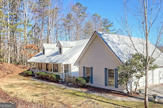 view of side of property with a lawn and covered porch