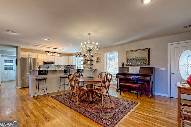 dining area featuring light hardwood / wood-style floors and a notable chandelier