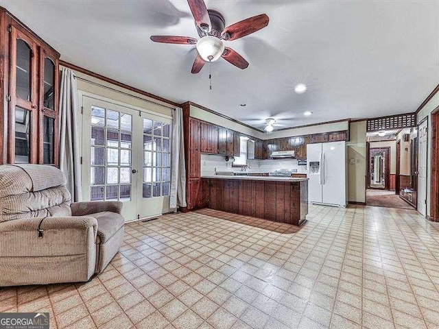 kitchen featuring ornamental molding, white refrigerator with ice dispenser, ceiling fan, kitchen peninsula, and french doors