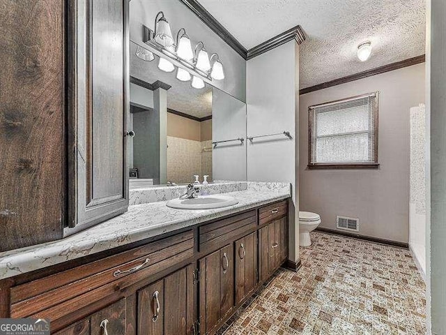 bathroom with ornamental molding, vanity, a textured ceiling, and toilet