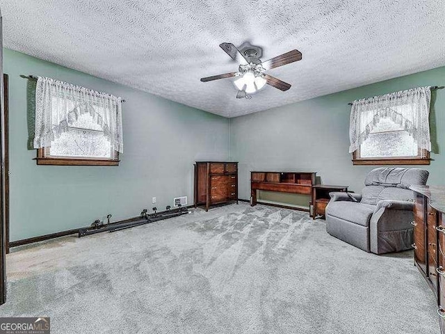 unfurnished room with light carpet, a textured ceiling, a wealth of natural light, and ceiling fan