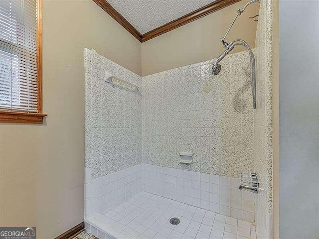 bathroom featuring crown molding, a textured ceiling, and tiled shower