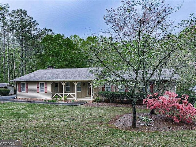 ranch-style home featuring a porch and a front yard