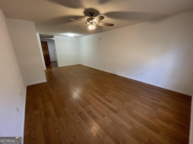 unfurnished room featuring dark hardwood / wood-style flooring, a textured ceiling, and ceiling fan