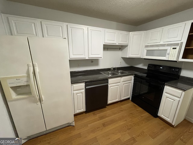 kitchen with hardwood / wood-style floors, sink, white cabinets, black appliances, and a textured ceiling