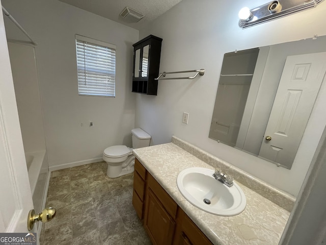 bathroom with vanity, a textured ceiling, and toilet