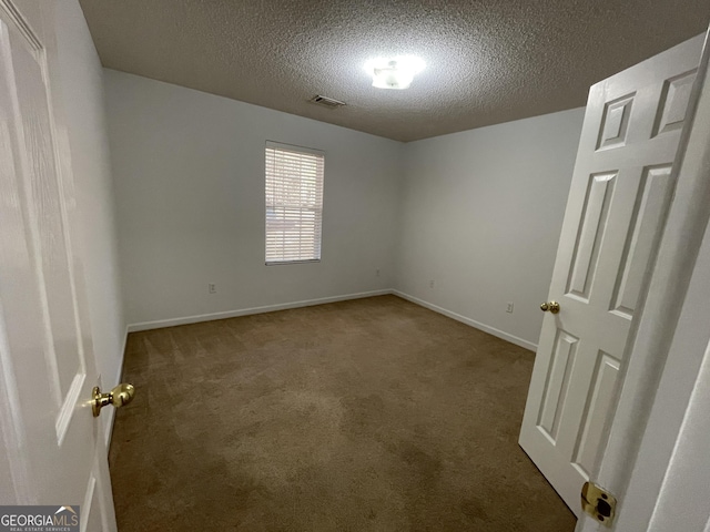 carpeted empty room with a textured ceiling