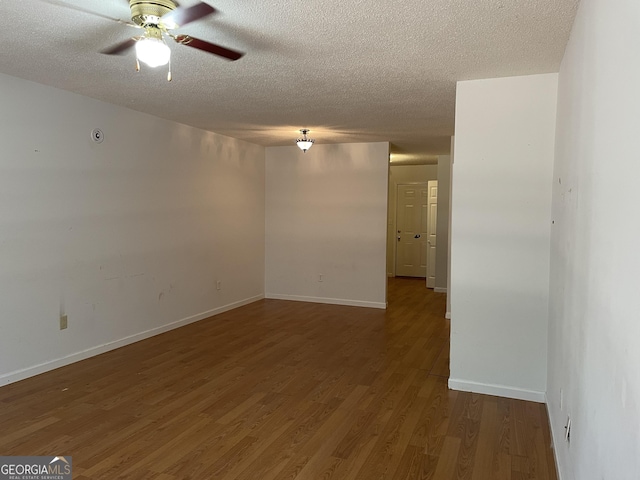 empty room featuring ceiling fan, dark hardwood / wood-style floors, and a textured ceiling