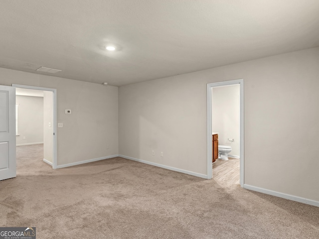 unfurnished room featuring light carpet and baseboards