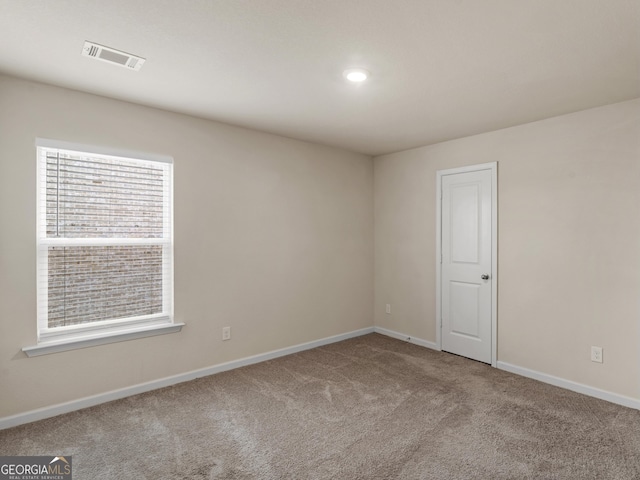 carpeted empty room featuring visible vents and baseboards