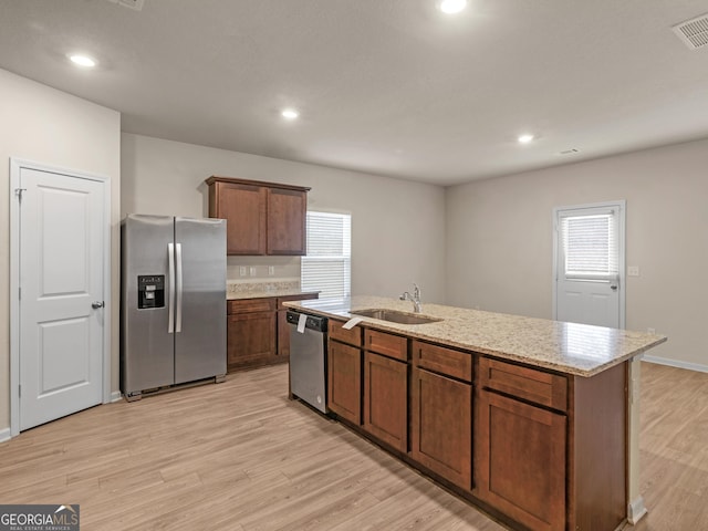 kitchen with visible vents, light wood-style flooring, appliances with stainless steel finishes, a healthy amount of sunlight, and a sink