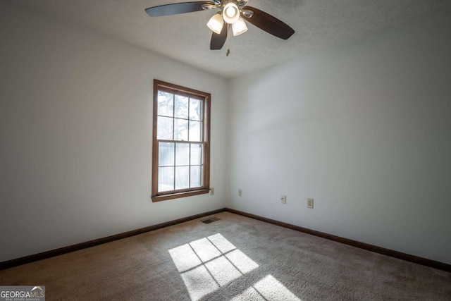 carpeted empty room featuring ceiling fan and a textured ceiling