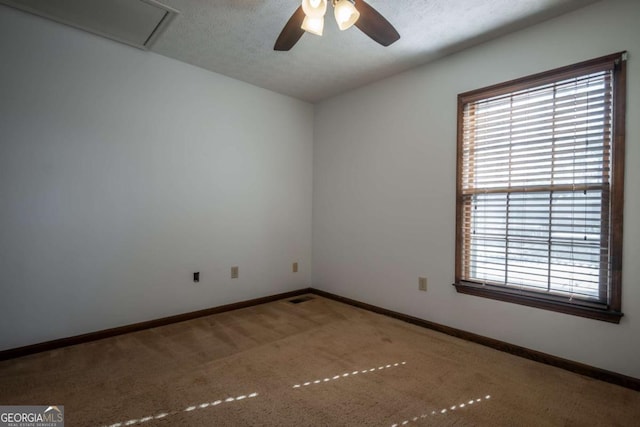 carpeted spare room with ceiling fan and a textured ceiling