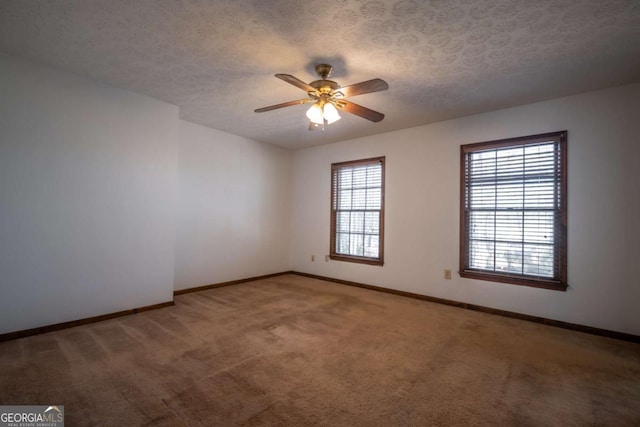 carpeted spare room featuring ceiling fan and a textured ceiling